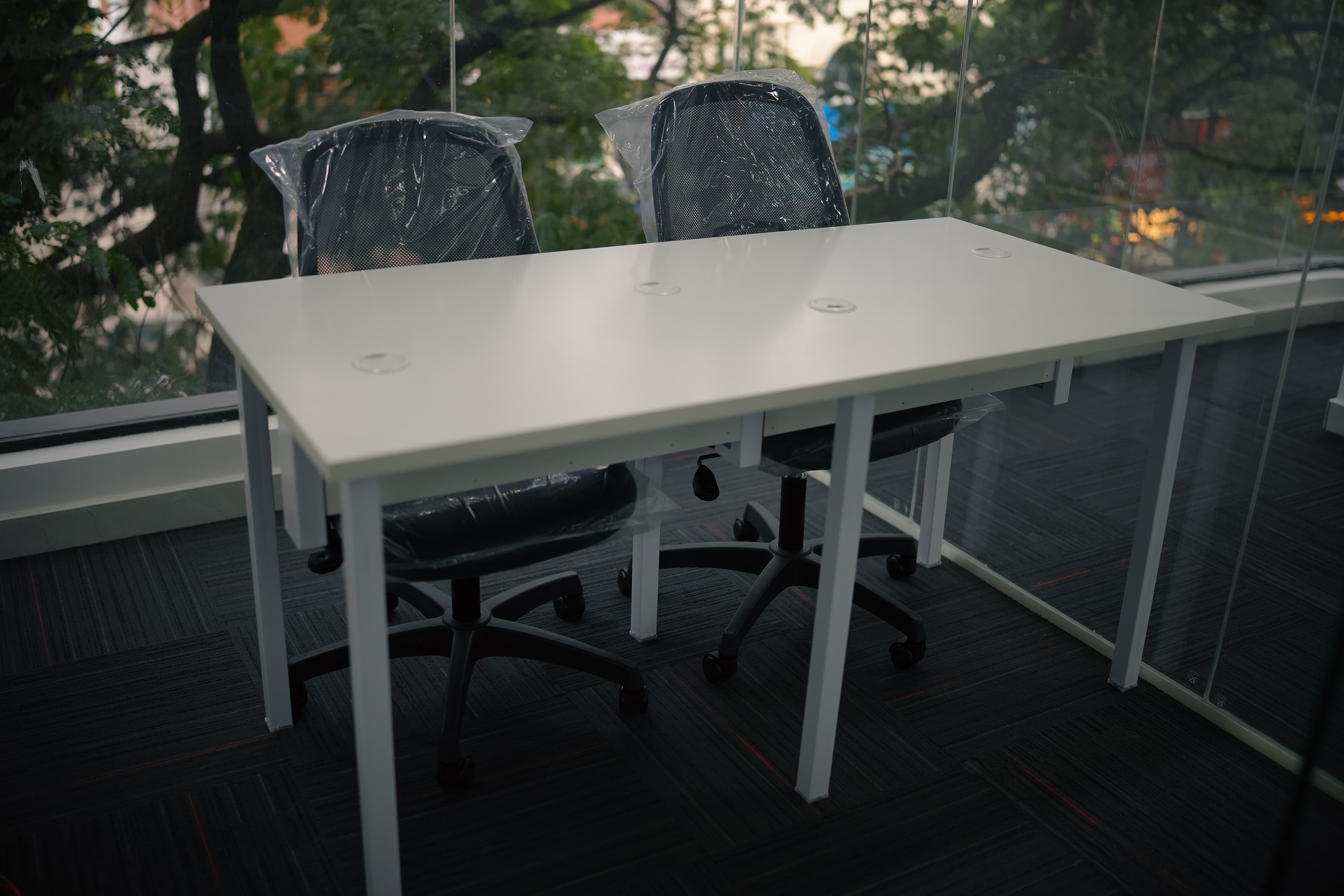 Dedicated desk with chairs beside a window